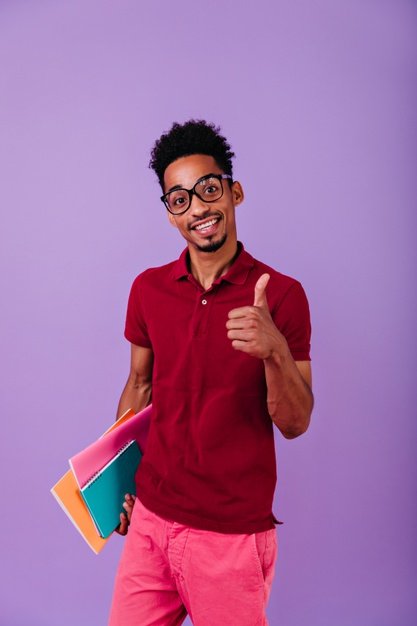 smart black student posing with thumb up indoor photo pleased african guy with books having fun after exams 197531 20292