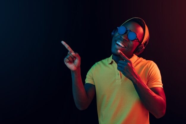 young handsome happy hipster man listening music with headphones black with neon lights 155003 26529 e1734111790169